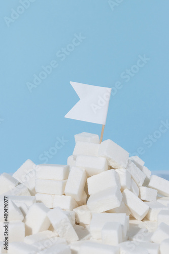 White flag planted on sugar cubes. Stop sugar addiction concept.