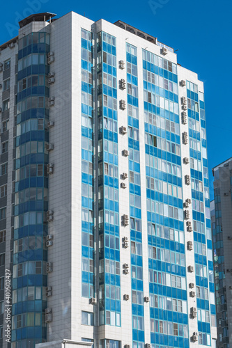 A modern multi-storey building with blue windows. Urban landscape