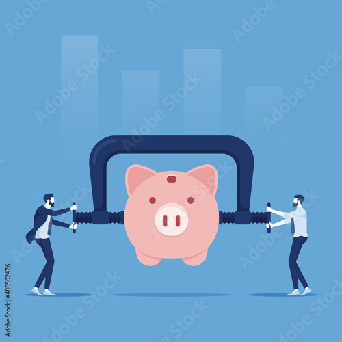 Business or company cut budget or reduce spending due to business crisis, businessman using clamp to squeeze saving pink piggy bank