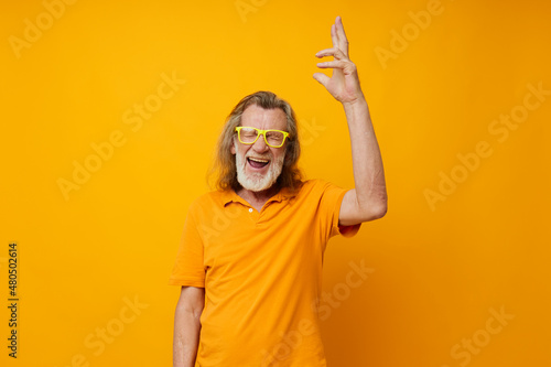 Senior grey-haired man hand gestures emotions yellow glasses monochrome shot photo