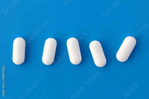 Εκτύπωση καμβά Five white oblong tablets lie on a blue background.