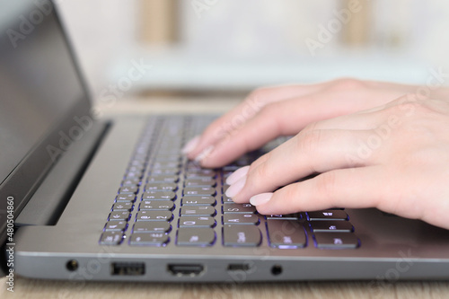 Closeup of business woman hand typing on laptop keyboard