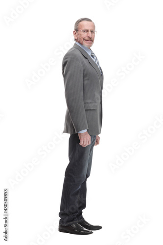 Senior man stands, arms crossed, with one hand on chin in thoughtful full length pose