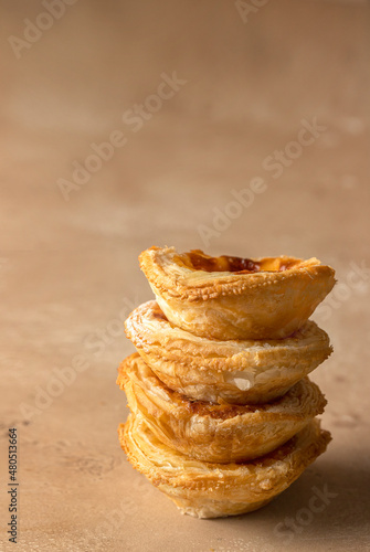 Close up of Pasteis de Belem stack. Typical Portuguese egg custard tart dusted with cinnamon. photo