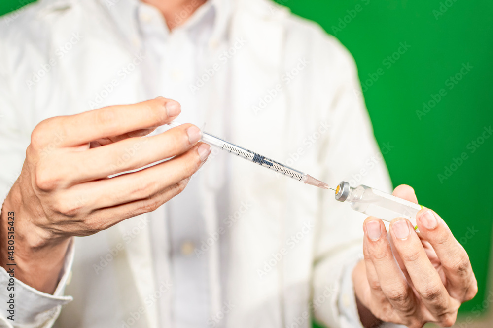 Close up of hands with syringes and capsule, syringe cure concept, doctor hands with syringe Close up of hands with syringes and capsule, syringe cure concept, doctor hands with syringe