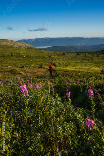 A man walks on the mountain peaks on a sunny day