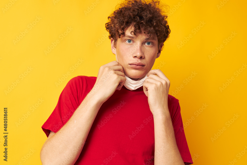 guy with red curly hair in a red t-shirt medical mask protection Lifestyle unaltered guy with red curly hair in a red t-shirt medical mask protection Lifestyle unaltered