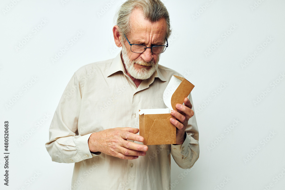 Old man with a box in his hands in studio alone Old man with a box in his hands in studio alone