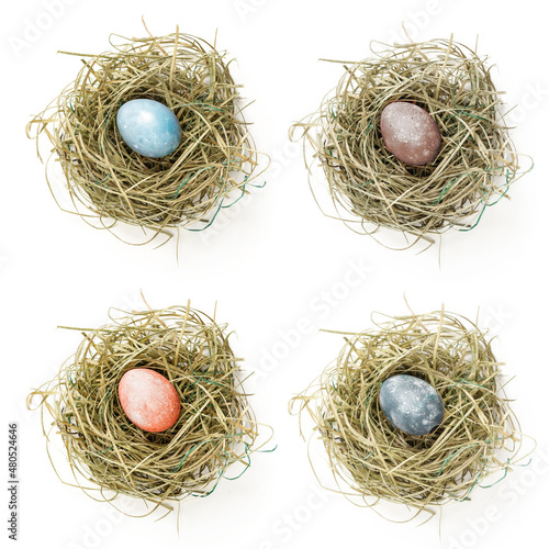 Fotografie, Obraz Painted easter egg in hay nest on white background