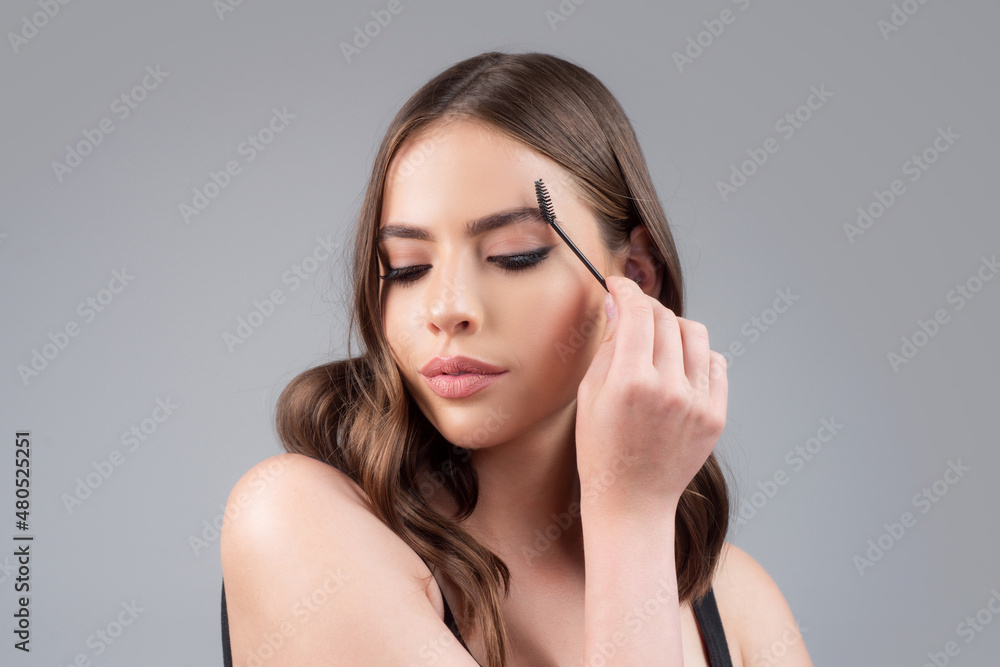 Beautiful woman with long eyelashes, eyebrows. Makeup and cosmetology concept. Woman portrait isolated on gray studio background. Beautiful woman with long eyelashes, eyebrows. Makeup and cosmetology concept. Woman portrait isolated on gray studio background.