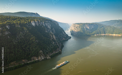 Visit beautiful Romania. Aerial view of a cruising ship traveling between Danube Gorges.