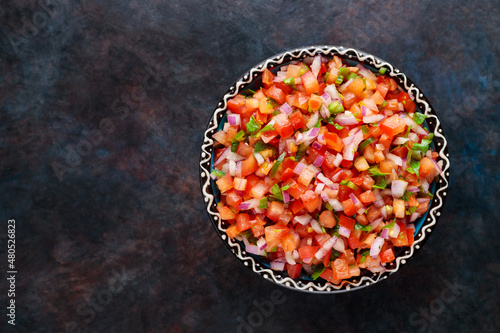 Pico de Gallo on a dark background. Homemade pico de gallo with tomatoes, peppers, jalapenos and red onions. Top view. Copy space photo