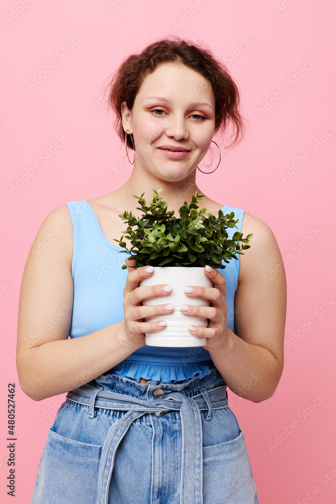portrait of a young woman holding a pot with a flower isolated backgrounds unaltered portrait of a young woman holding a pot with a flower isolated backgrounds unaltered