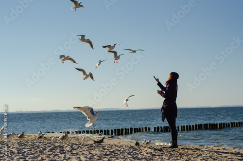 Dziewczyna i ptaki na morskiej plaży