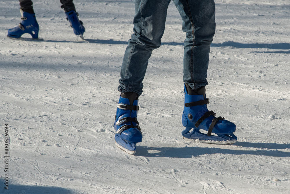 Bibbiano, December 2021. Legs and skates on a small skating rink in the town square Bibbiano, December 2021. Legs and skates on a small skating rink in the town square