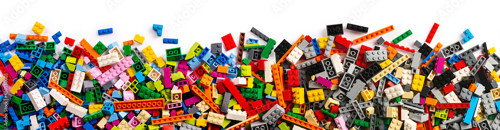 top view of wide pile various mixed colorful rainbow colored stackable plastic toy bricks isolated white panorama background.. childhood education construction concept - obrazy, fototapety, plakaty 