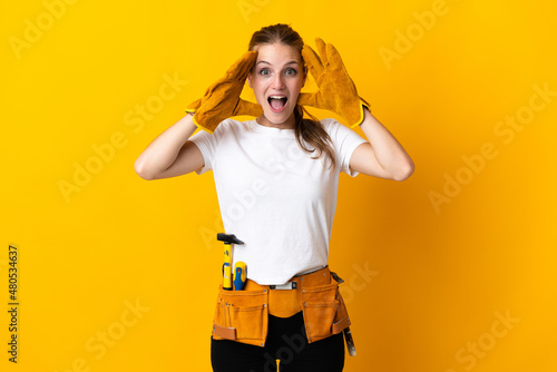 Young electrician woman isolated on yellow background with surprise expression