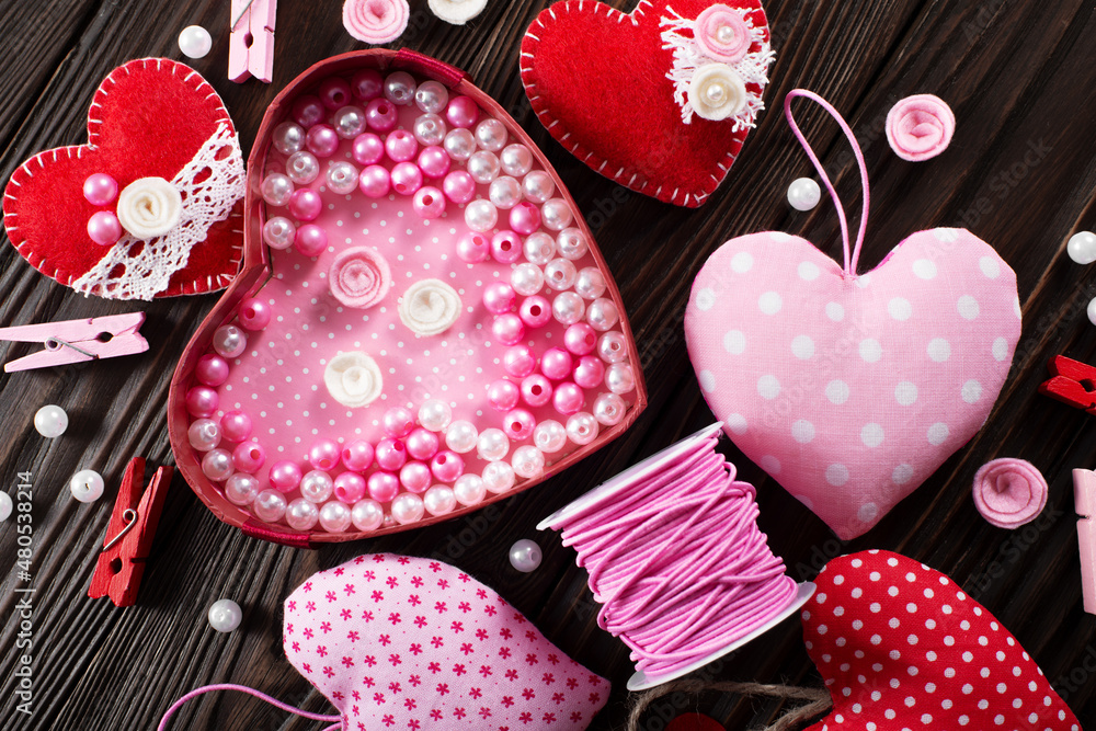 DIY Valentine hearts laundry pins and sewing spool on wooden table flat lay