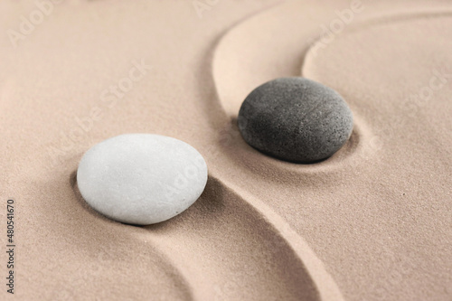 The yin and yang symbol. Balance. Good and evil. Stone garden for meditation. Japanese Zen concept. Buddhism and mindfulness. Concentration and concentration. Round stones on a sandy background. Philo