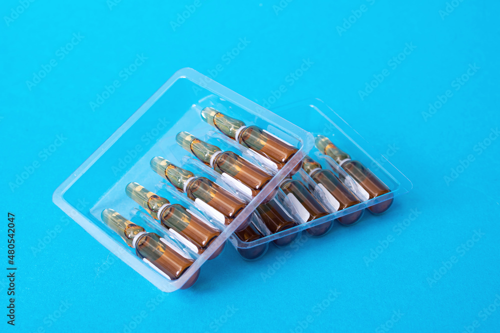 Ampoules with medicine on a blue background