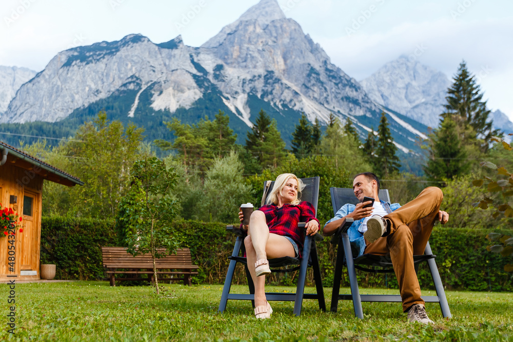 Obraz premium Young lovers relaxing on holiday in beautiful panorama with mountains Bavaria Germany. Couple in love relaxing in spring