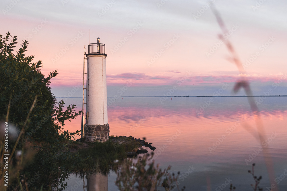 Sonnenuntergang am Meer mit Spiegelung und Steinen am Leuchtturm Maltzien auf der Insel Rügen Ostsee in Deutschland