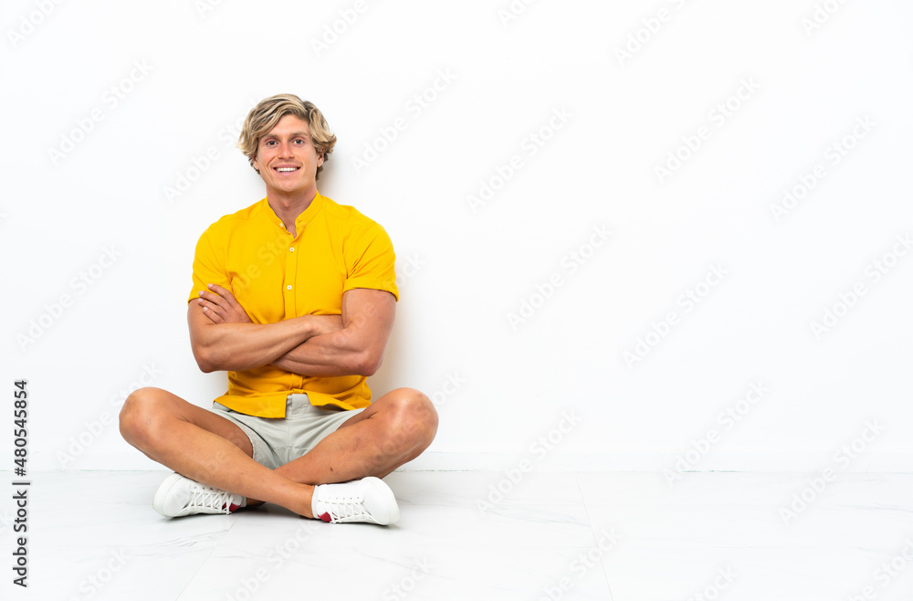 Young English man sitting on the floor laughing Young English man sitting on the floor laughing