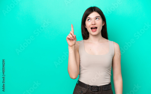 Young Russian woman isolated on green background intending to realizes the solution while lifting a finger up