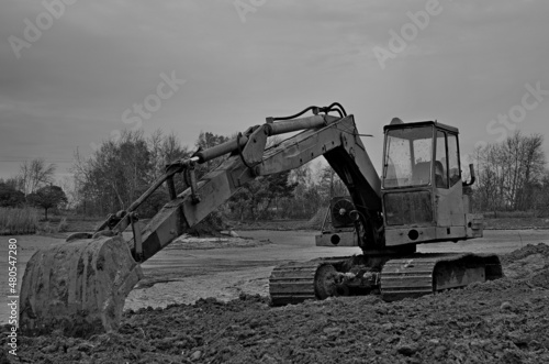 A tracked excavator during a break in works on a water reservoir.