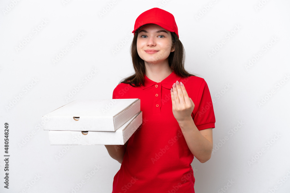 Young Russian pizza delivery picking up pizza boxes isolated on white background inviting to come with hand. Happy that you came Young Russian pizza delivery picking up pizza boxes isolated on white background inviting to come with hand. Happy that you came