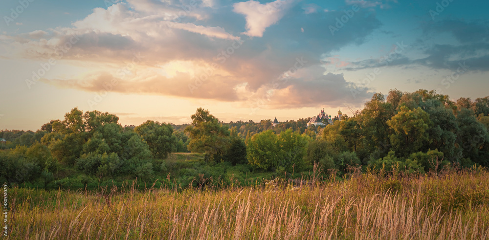 Autumn landscape with forest and old monastery at sunset Autumn landscape with forest and old monastery at sunset