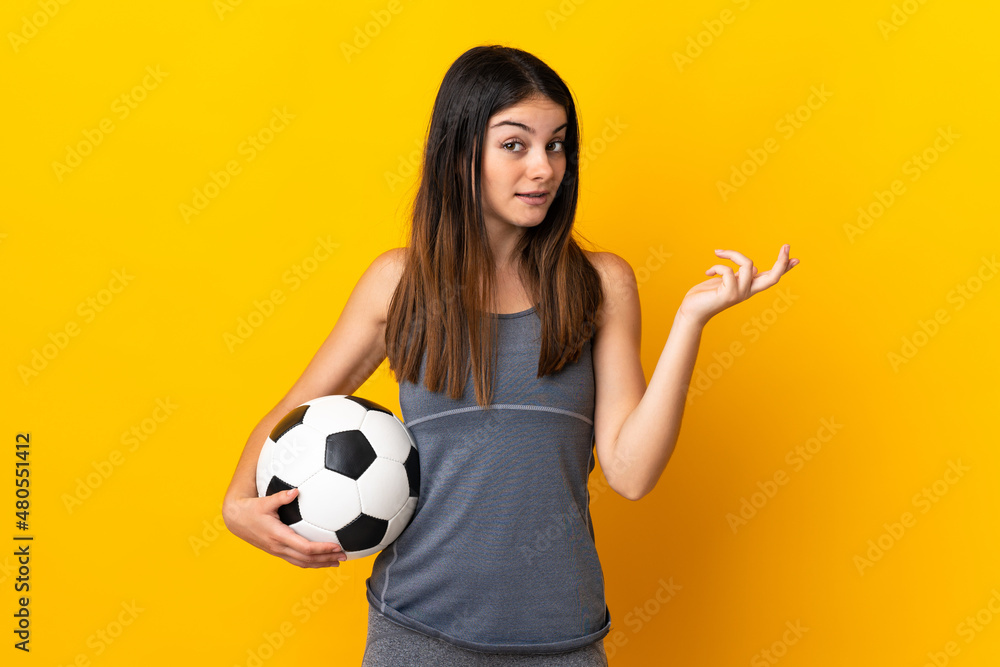 Young football player woman isolated on yellow background extending hands to the side for inviting to come Young football player woman isolated on yellow background extending hands to the side for inviting to come