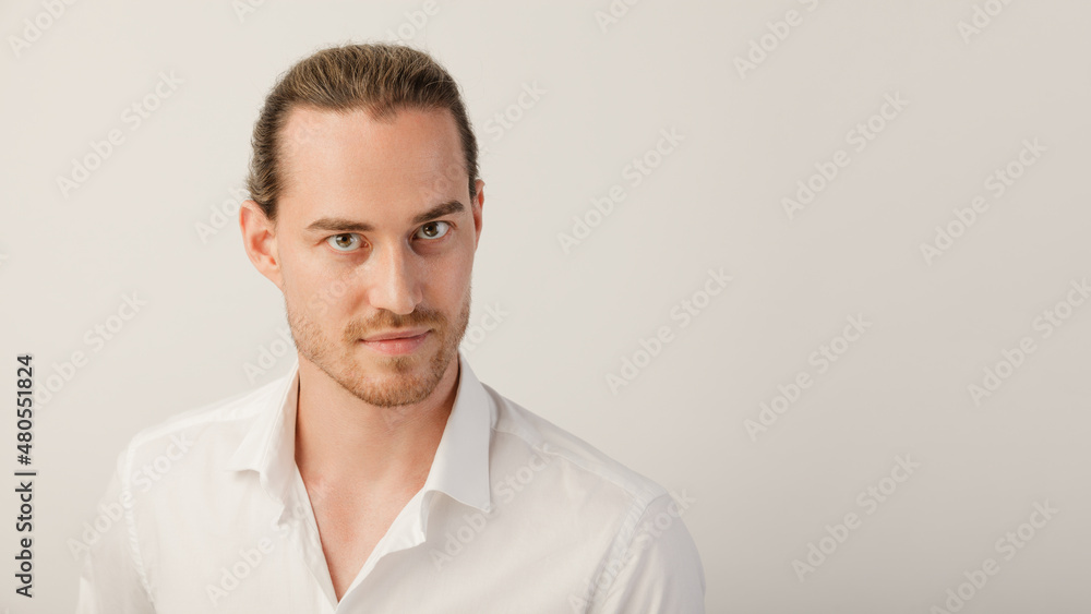 Young blonde bearded man looking in camera. Portrait of caucasian guy with trendy hairdo isolated over a white studio background with copy space Young blonde bearded man looking in camera. Portrait of caucasian guy with trendy hairdo isolated over a white studio background with copy space