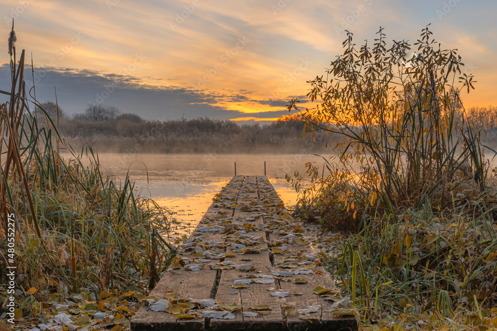 Fototapeta premium Sunrise over the river with wooden pier on beautiful October's morning