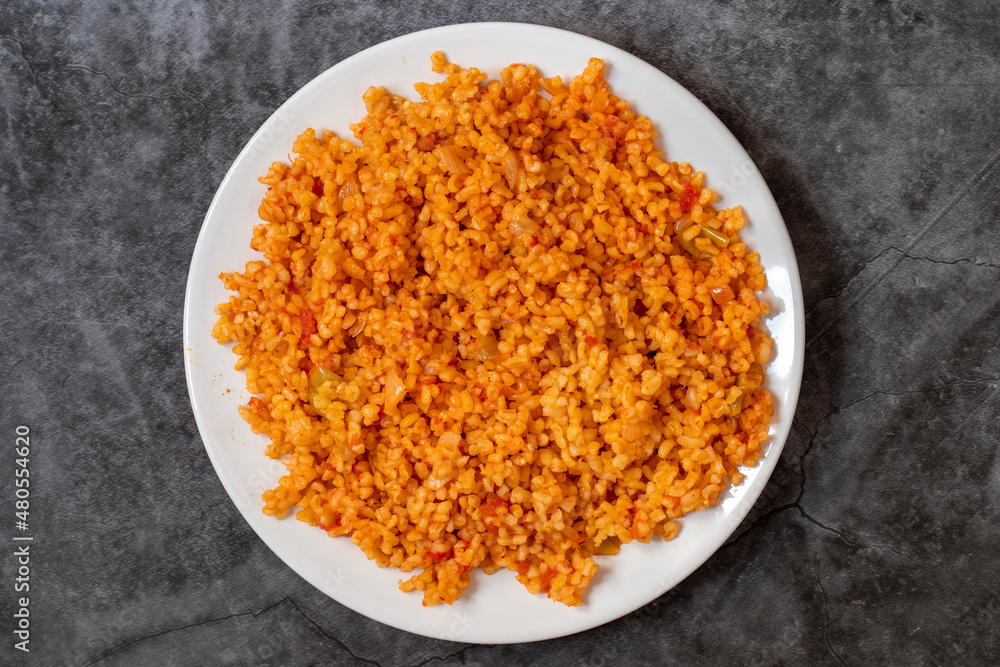 Bulgur pilaf on a dark background. Close-up of Turkish food Bulgur Pilav in a ceramic plate. Top view Bulgur pilaf on a dark background. Close-up of Turkish food Bulgur Pilav in a ceramic plate. Top view