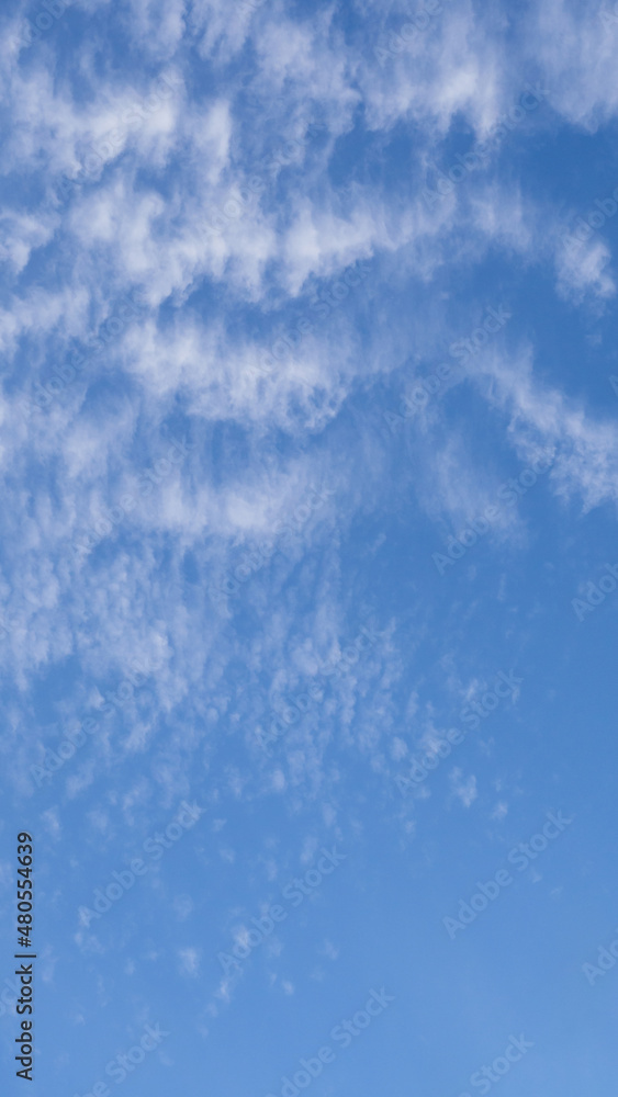 Abstract texture background of white clouds and blue sky. Peaceful blue sky with white feathery clouds