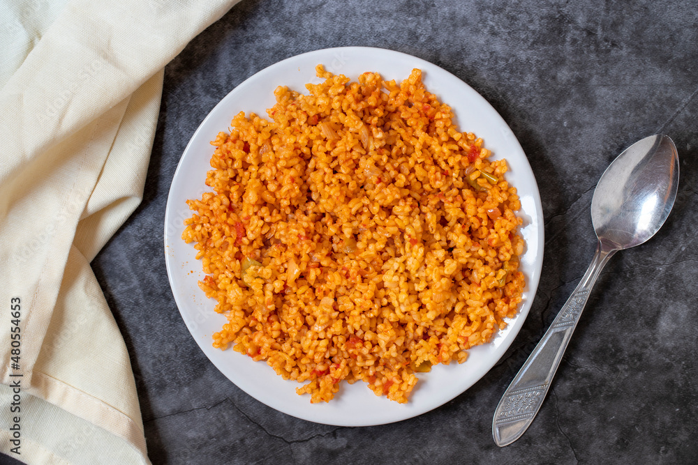 Bulgur pilaf on a dark background. Close-up of Turkish food Bulgur Pilav in a ceramic plate. Top view Bulgur pilaf on a dark background. Close-up of Turkish food Bulgur Pilav in a ceramic plate. Top view