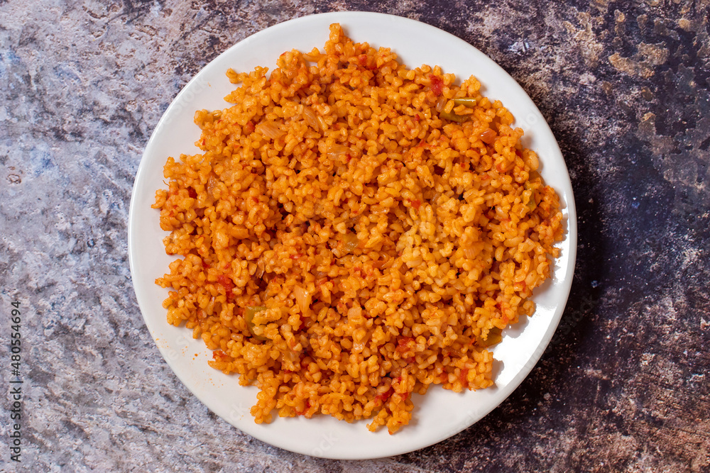 Bulgur pilaf on a dark background. Close-up of Turkish food Bulgur Pilav in a ceramic plate. Top view Bulgur pilaf on a dark background. Close-up of Turkish food Bulgur Pilav in a ceramic plate. Top view