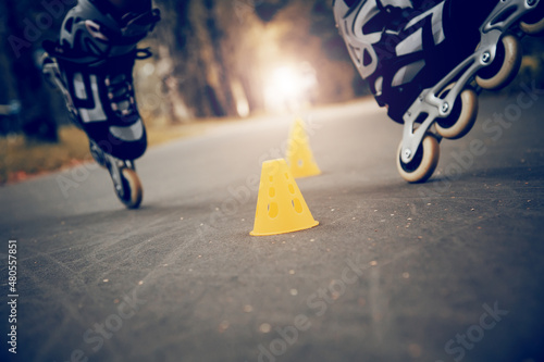 Tableau sur toile Roller skating slalom around yellow cones