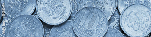 Surface of many Russian coins of 1 one ruble. Blue tinted banner. Light headline on the theme of economy, finance and the central bank of Russia. Macro