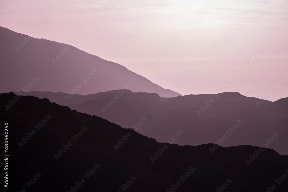Beautiful layered mountain landscape image with magenta light at sunrise