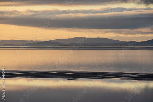 Beautiful sunset landscape image of Solway Firth viewed from Silloth during stunning Autumn sunset with dramatic sky and cloud formations