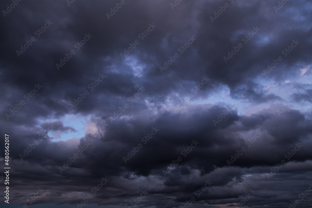 Obraz premium Epic Dramatic storm dark grey cumulus rain clouds against blue sky background texture, thunderstorm
