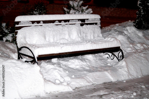 benches in a city park under a layer of snow