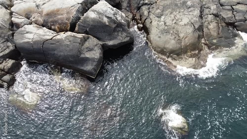 Aerial, drone footage of archipelago in northern Gothenburg, Sweden. Bird's eye view of coastline and sea. Small waves hit the rocks, seen from above. photo