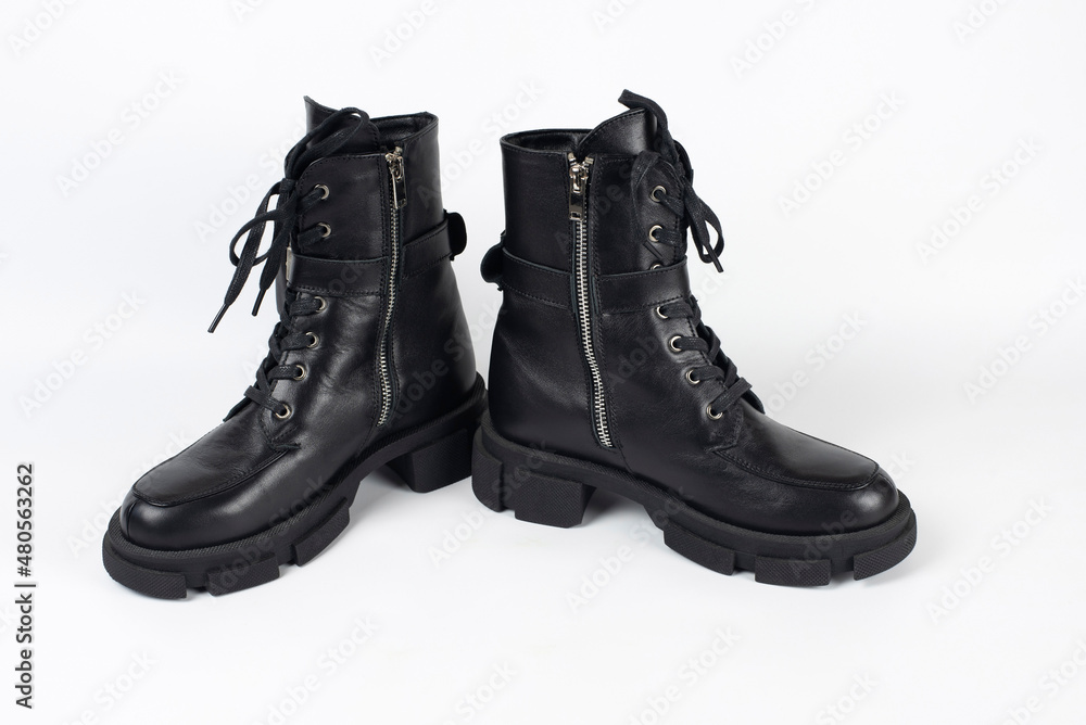 Dark leather boots for the cold season for young girls, teenagers on a light background, shoes with insulation inside and do not get wet