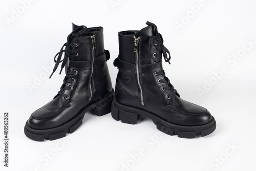 Dark leather boots for the cold season for young girls, teenagers on a light background, shoes with insulation inside and do not get wet