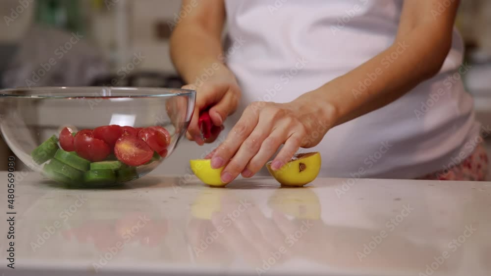 Pregnant woman Cutting a lemon for a salad. Healthy food concept. Pregnant woman Cutting a lemon for a salad. Healthy food concept.