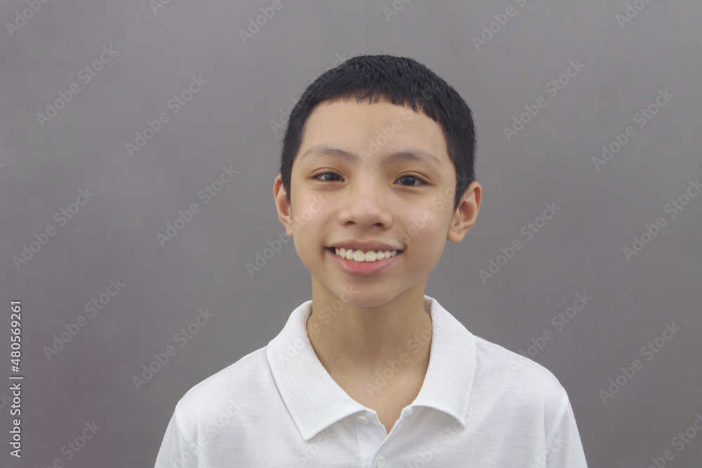 Portrait of positive, handsome and friendly Asian boy on gray background. Portrait of positive, handsome and friendly Asian boy on gray background.