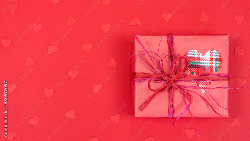 Gift box with a heart on a red background. Advertising banner concept for Valentine's Day. Valentine's day concept background for postcard, sale banner, advertisement.